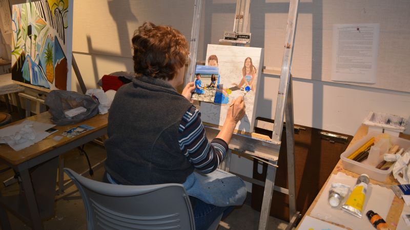 Art student doing a painting of a family portrait.